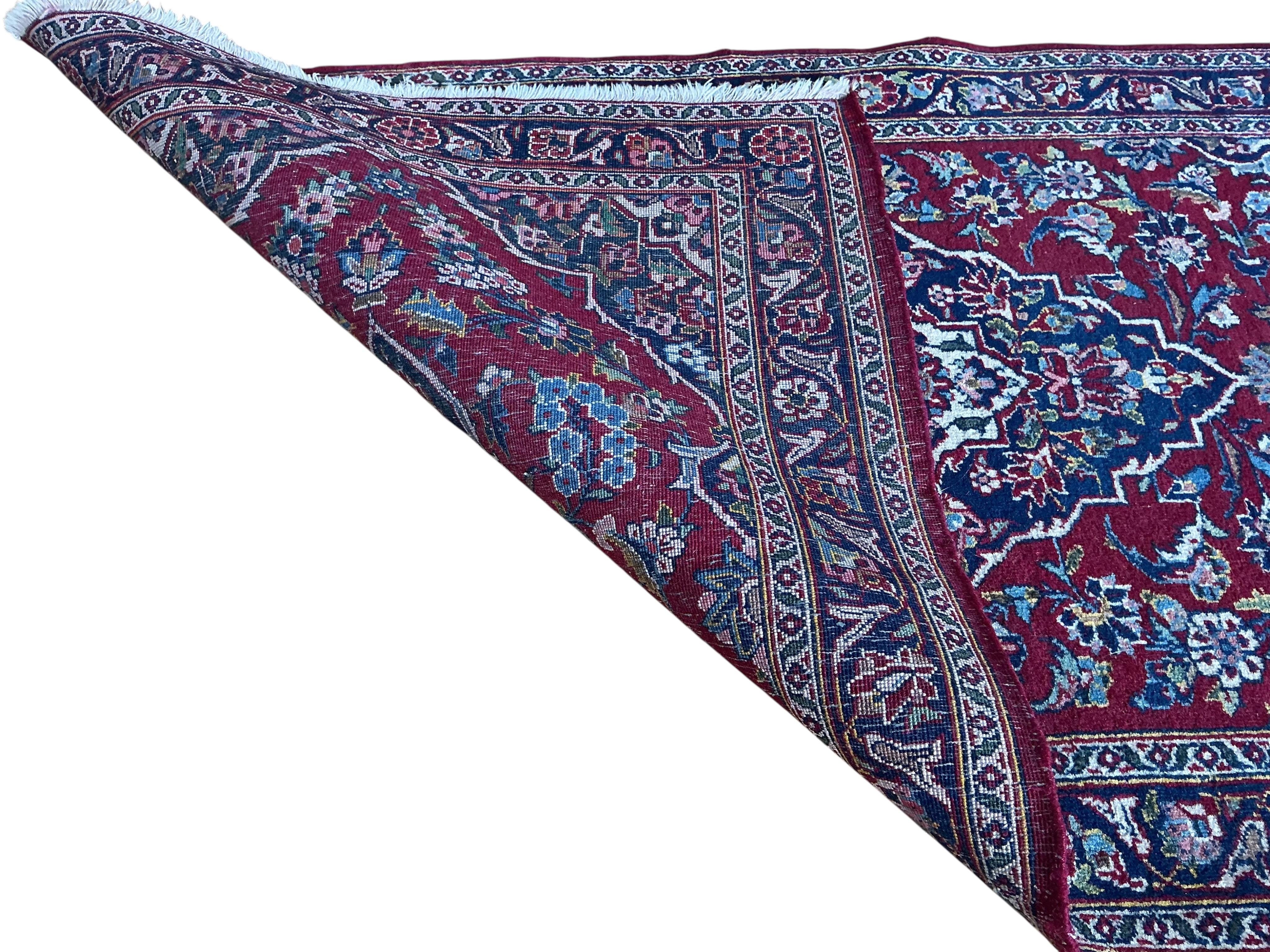 A North West Persian burgundy ground rug, 130 x 70cm